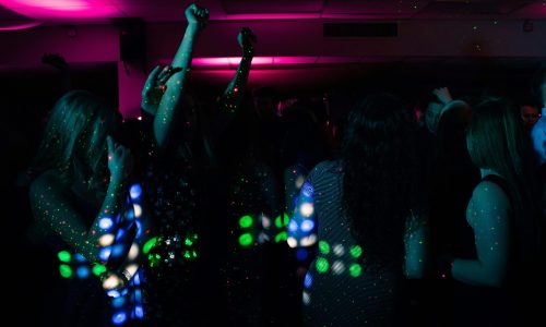 Energetic nightclub scene with people dancing under colorful neon lights. Perfect for nightlife themes.